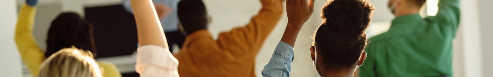 Students raising their hands in class